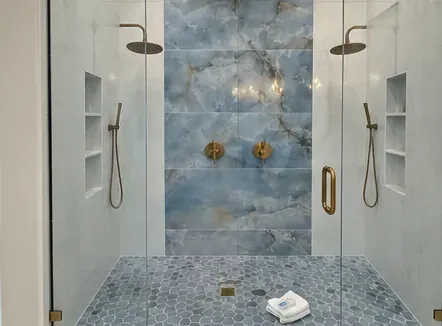 Walk-in shower with blue onyx tile and twin rain heads